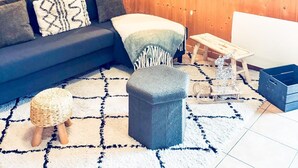 Ein gemütliches Zimmer mit Holzwand, einer Couch, einem kleinen Tisch und einer Bank.
