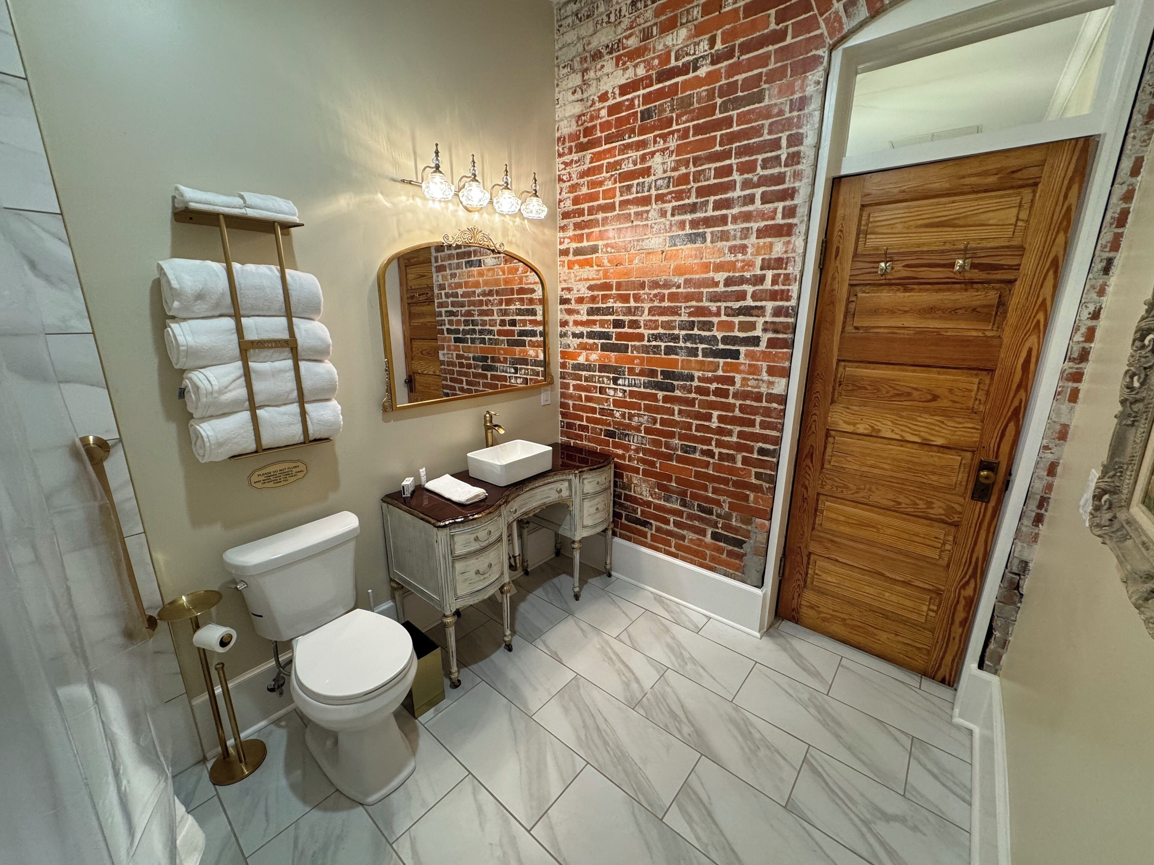 A bathroom with a toilet, sink, and towel rack.