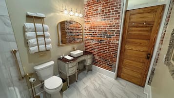 A bathroom with a toilet, sink, and towel rack.