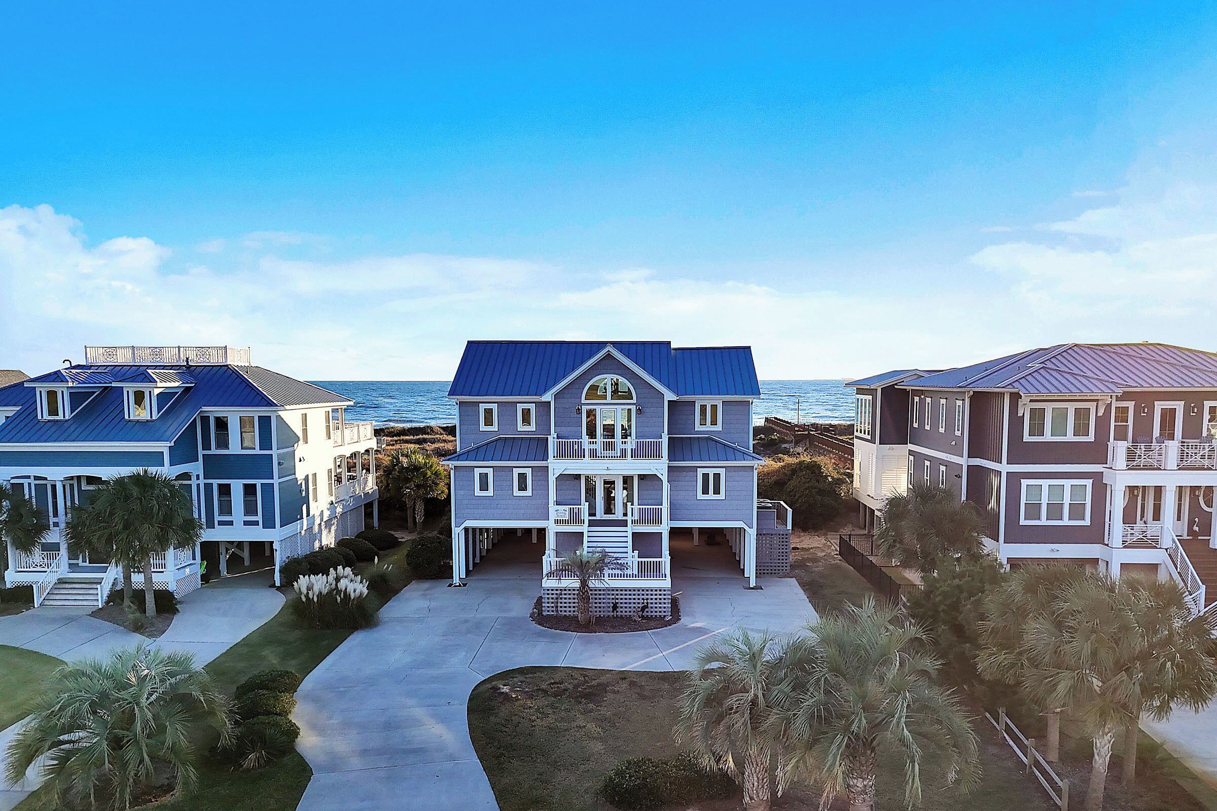 A beachfront property with multiple houses, a central entrance, and a pathway leading to the ocean.