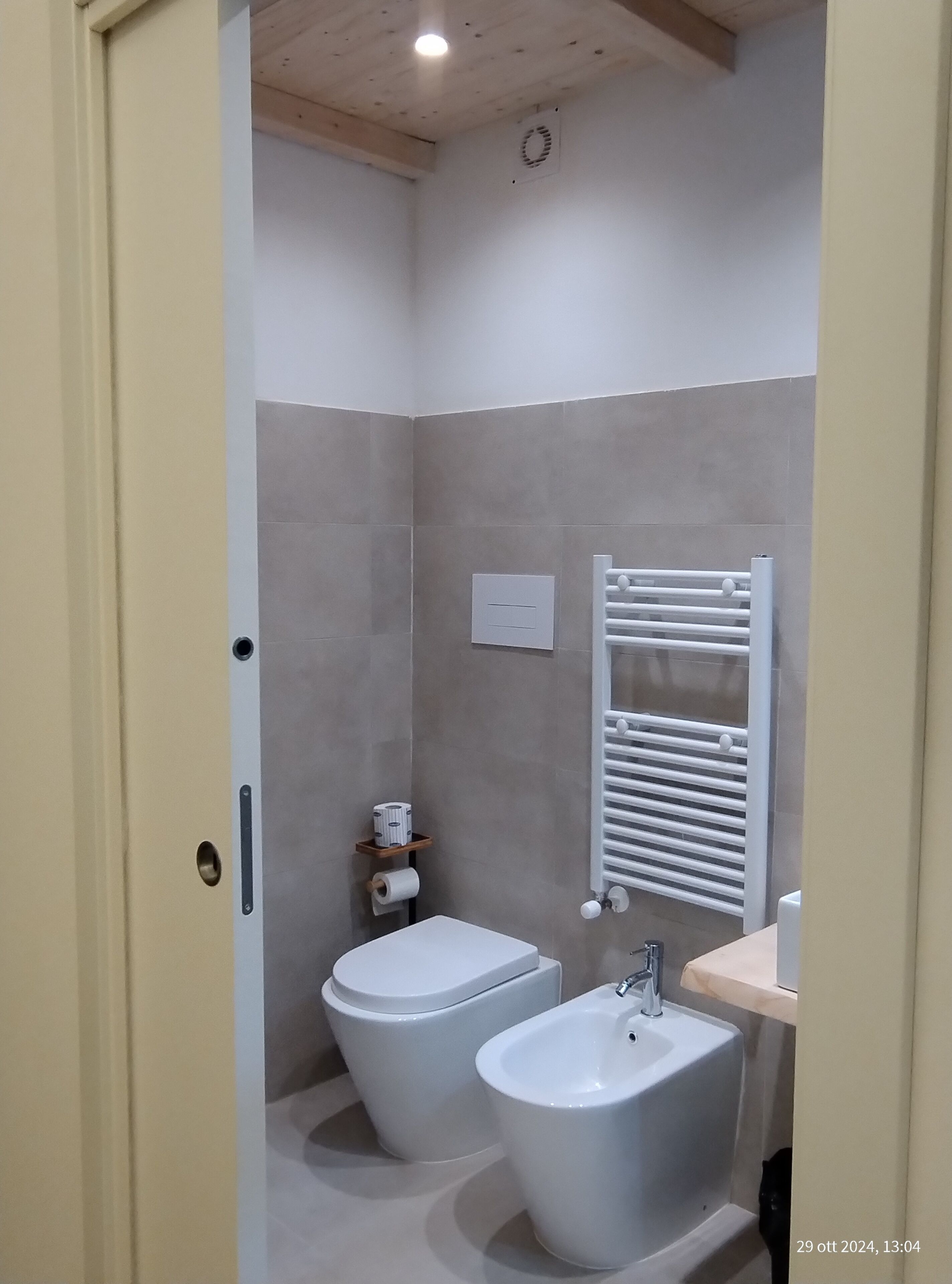 A modern bathroom with a toilet, bidet, and sink.