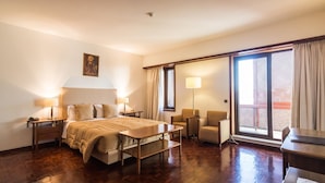 A hotel room with a bed, bedside tables, a desk, a chair, a sofa, and a balcony with curtains. - Lam Hotel Fortaleza de Almeida (Almeida)
