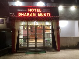 Entrada de un hotel con un cartel que dice "HOTEL DHARAM MUKTI".