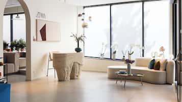 Una sala de estar moderna con un ventanal grande, una pared de acento de piedra y un sofá con cojines.