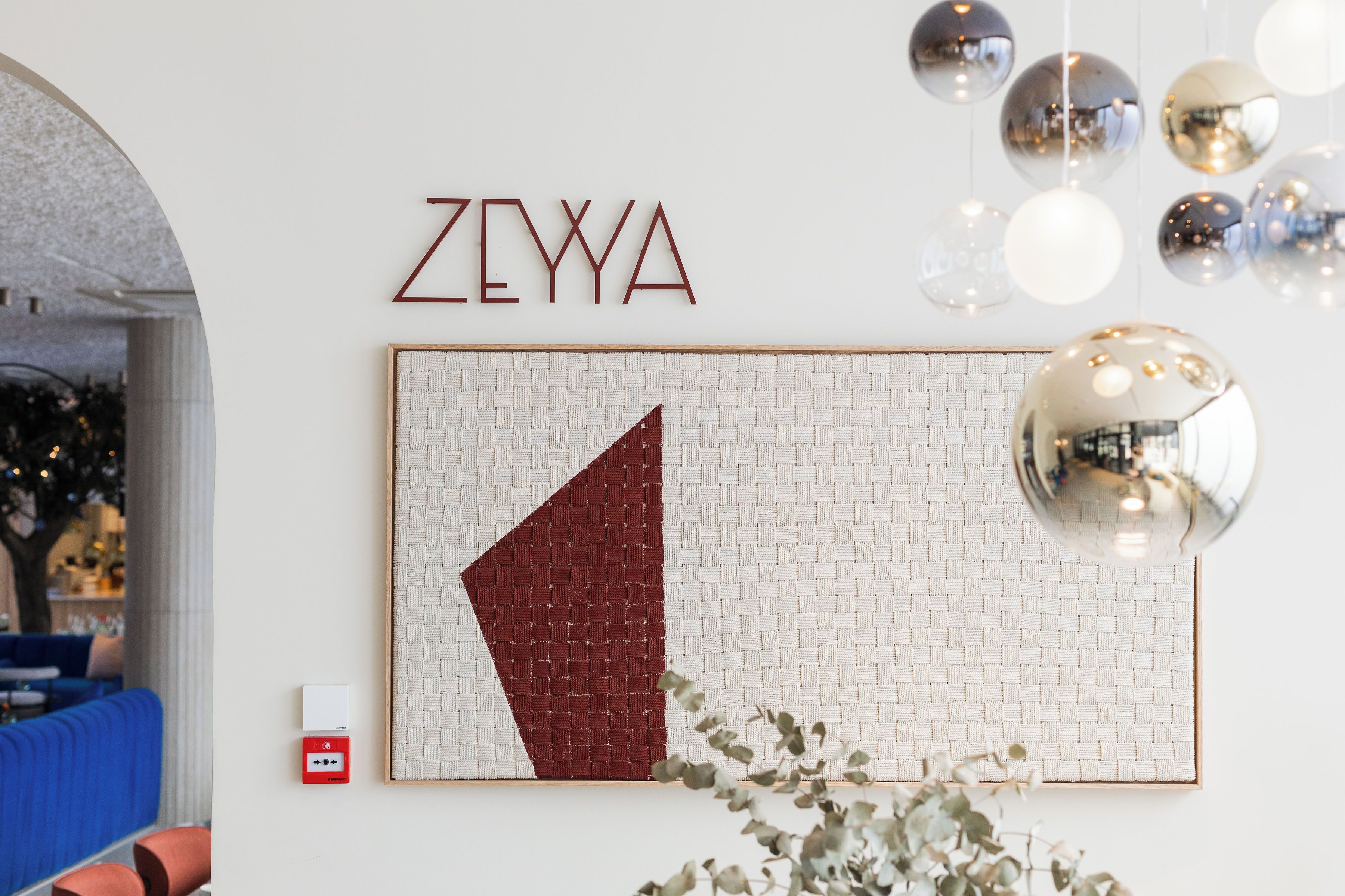 Un muro con il nome 'ZEYYA' e un'opera d'arte geometrica.