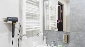 Habitación familiar con 1 cama matrimonial o 2 individuales, vista al jardín | Baño | Regadera, secadora de cabello, pantuflas, toallas