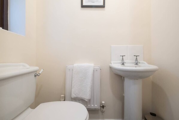 A standard bathroom with a toilet, a sink, and a towel rack.