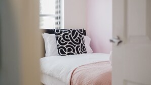 Una camera da letto con un letto, una finestra con persiane e una porta.