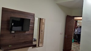 A hallway with a wooden panel and a television mounted on the wall. - Hotel Relaxx Luxury (Amritsar)
