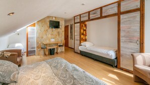 Une chambre à coucher avec un lit, un bureau et un téléviseur fixé au mur.