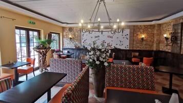 Un restaurante con pared de piedra, una araña y un letrero que dice 'Smile' y 'Love'.