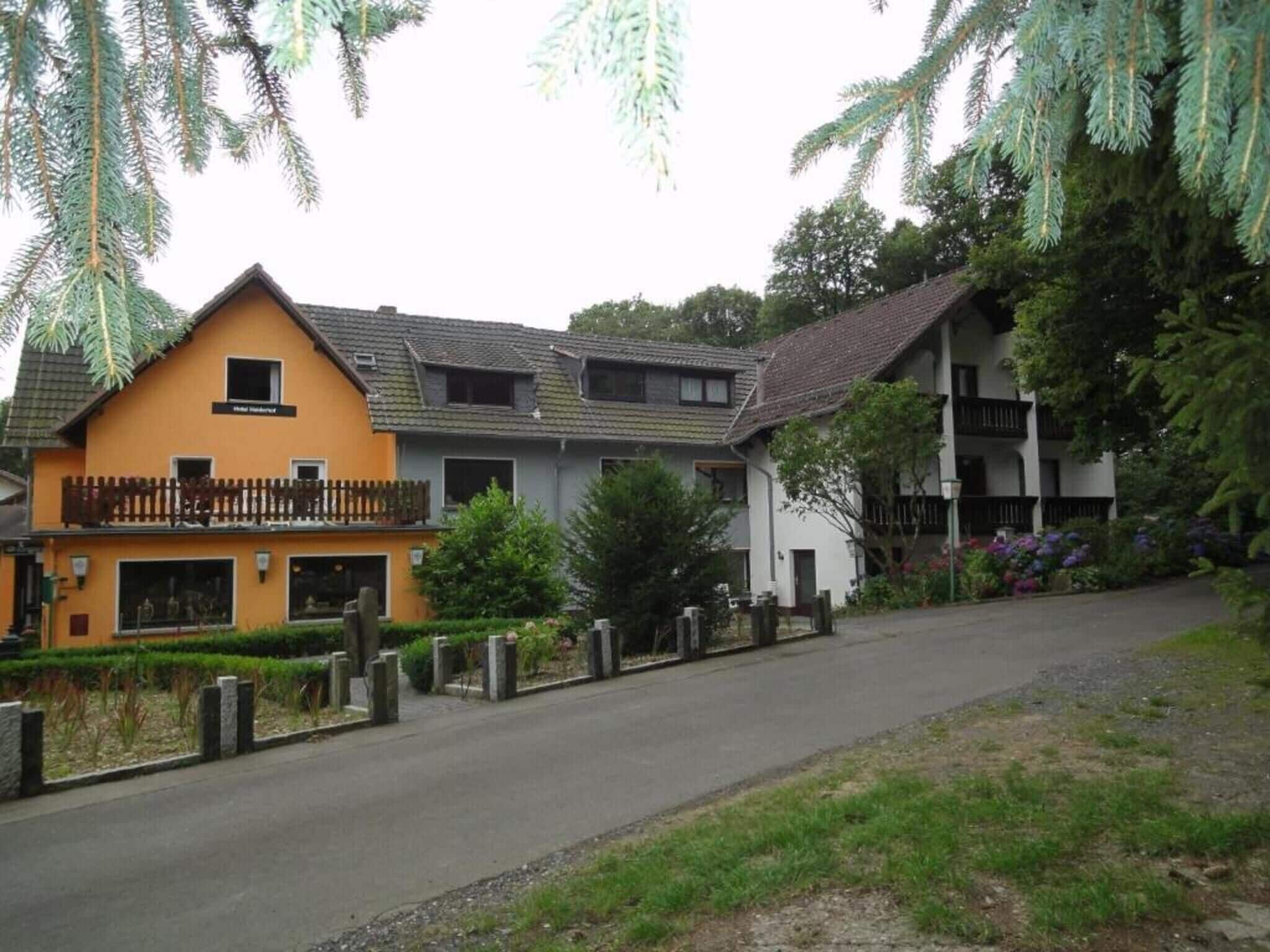 Ein zweistöckiges Gebäude mit Balkon, kleinem Fenster und einem Schild, auf dem 'Hotel' steht.
