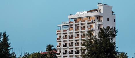 A multi-story hotel with a modern design, featuring balconies and a prominent "ARRIVAL" sign on the top.