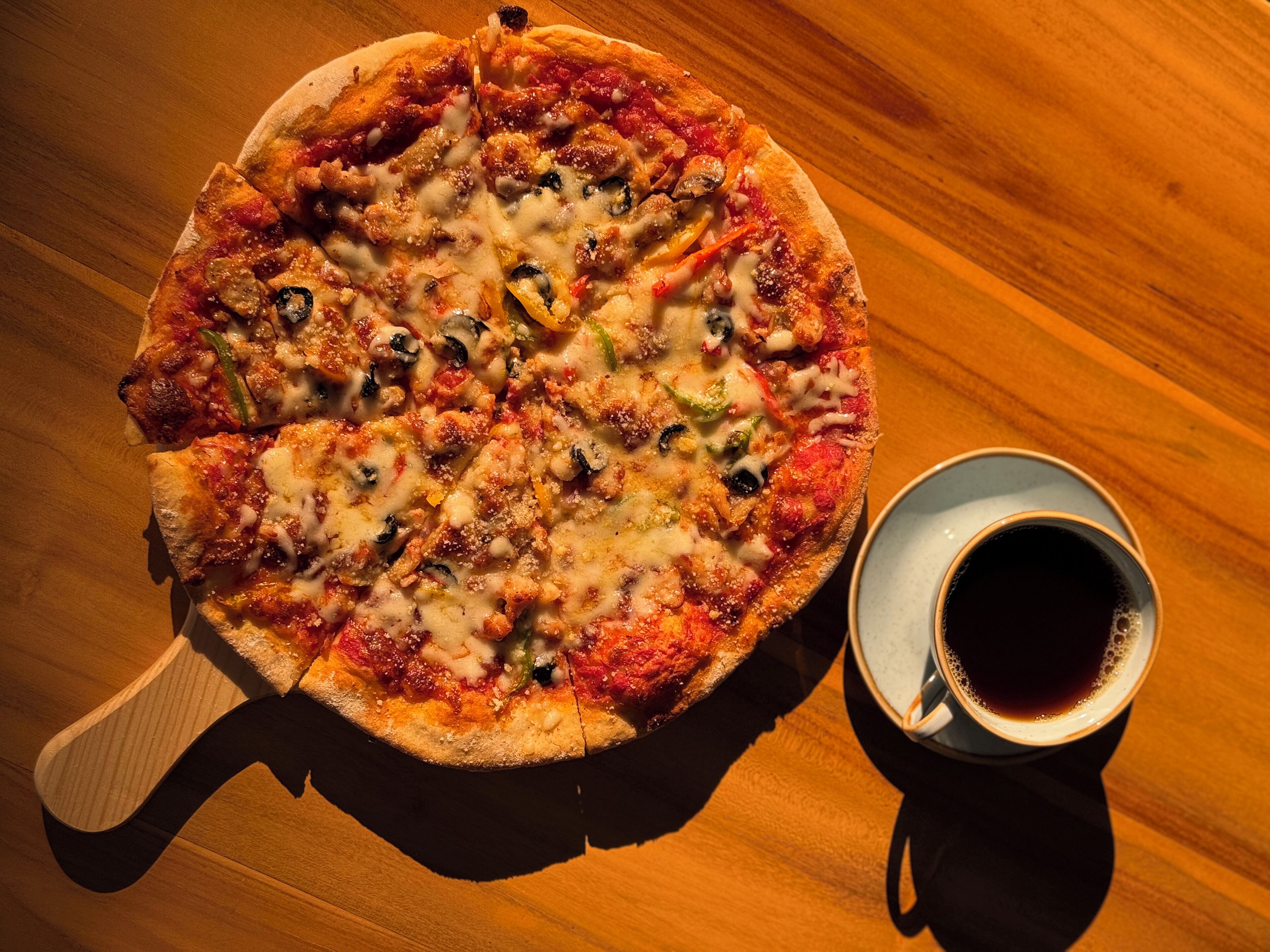 Eine Pizza mit verschiedenen Belägen auf einem Holztisch.