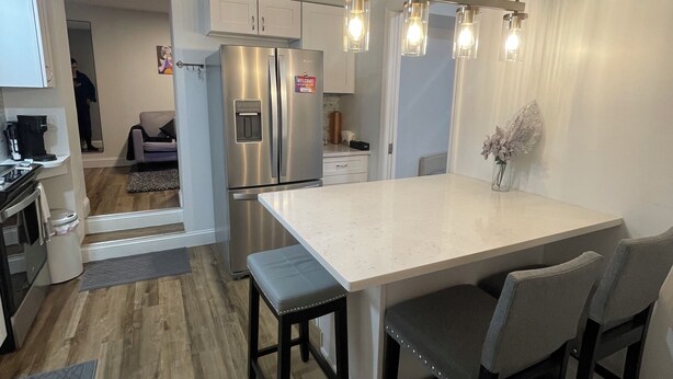 A modern kitchen with a central island, stainless steel appliances, and pendant lighting. - Modern 2BR Near NYC • Free Parking • Quiet Area (Yonkers)