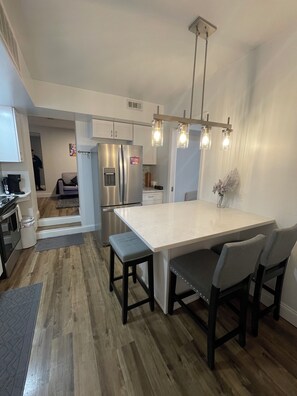 A modern kitchen with a central island, stainless steel appliances, and pendant lighting.