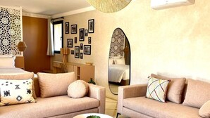 A modern living room with a sofa set, a round coffee table, and a patterned rug.
