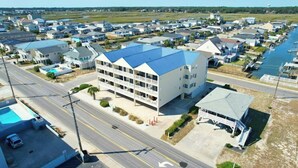 A multi-story hotel with a blue roof, located near a body of water with boats. - Grove Pointe 303-2BR/2BA-2nd Row-Oceanview (North Myrtle Beach)