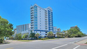 A multi-story hotel with a modern design, featuring balconies, a parking lot, and a clear blue sky. - Horizon PH2 -2BR/2BA -Myrtle Beach -I/O Pools (Myrtle Beach)