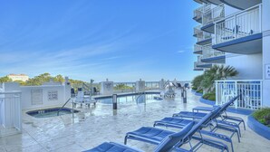 A rooftop pool area with lounge chairs, a pool, and a building with balconies. - Horizon PH2 -2BR/2BA -Myrtle Beach -I/O Pools (Myrtle Beach)
