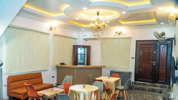 A hotel lobby with a reception desk, seating area with tables and chairs, and a chandelier. - Ringruby Hotel, United Estate (Lekki)