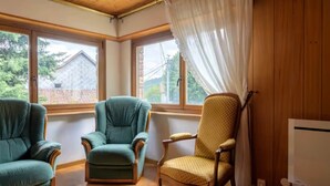 A room with three chairs, large windows, and wooden walls. - Le Gîte de Pipala *** (Mittlach)