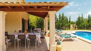 An outdoor dining area with a pool and lounge chairs. - Finca Carlotta with pool, garden, A/C in the bedrooms, Wifi, beach approx. 4 km (IB)