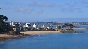 A coastal town with houses along the beach, a clear sky, and calm sea. - Apartment in Carantec Near Sandy Beaches (Carantec)