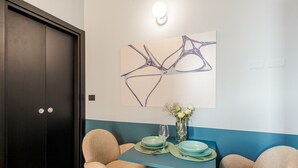 Een moderne kamer met een donker houten deur, een blauw-witte muur en een tafel gedekt met groene borden en een bloevas.