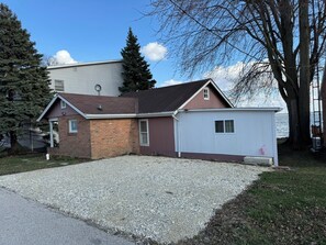 A two-story house with a gravel driveway and a small shed. - 10 out of 10 for Waterfront 2-bdrm Cottage on Grand Lake w/Seasonal Fishing Pier (Celina)