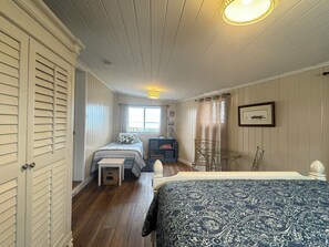 A bedroom with a bed, a small table, a chair, a window with a view, and a bookshelf. - 10 out of 10 for Waterfront 2-bdrm Cottage on Grand Lake w/Seasonal Fishing Pier (Celina)