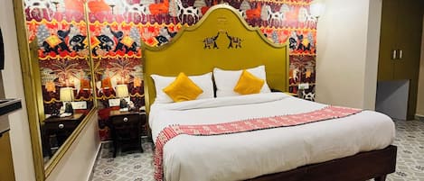 Une chambre à coucher avec un grand lit, une tête de lit ornée de motifs décoratifs, une table de chevet et un miroir.