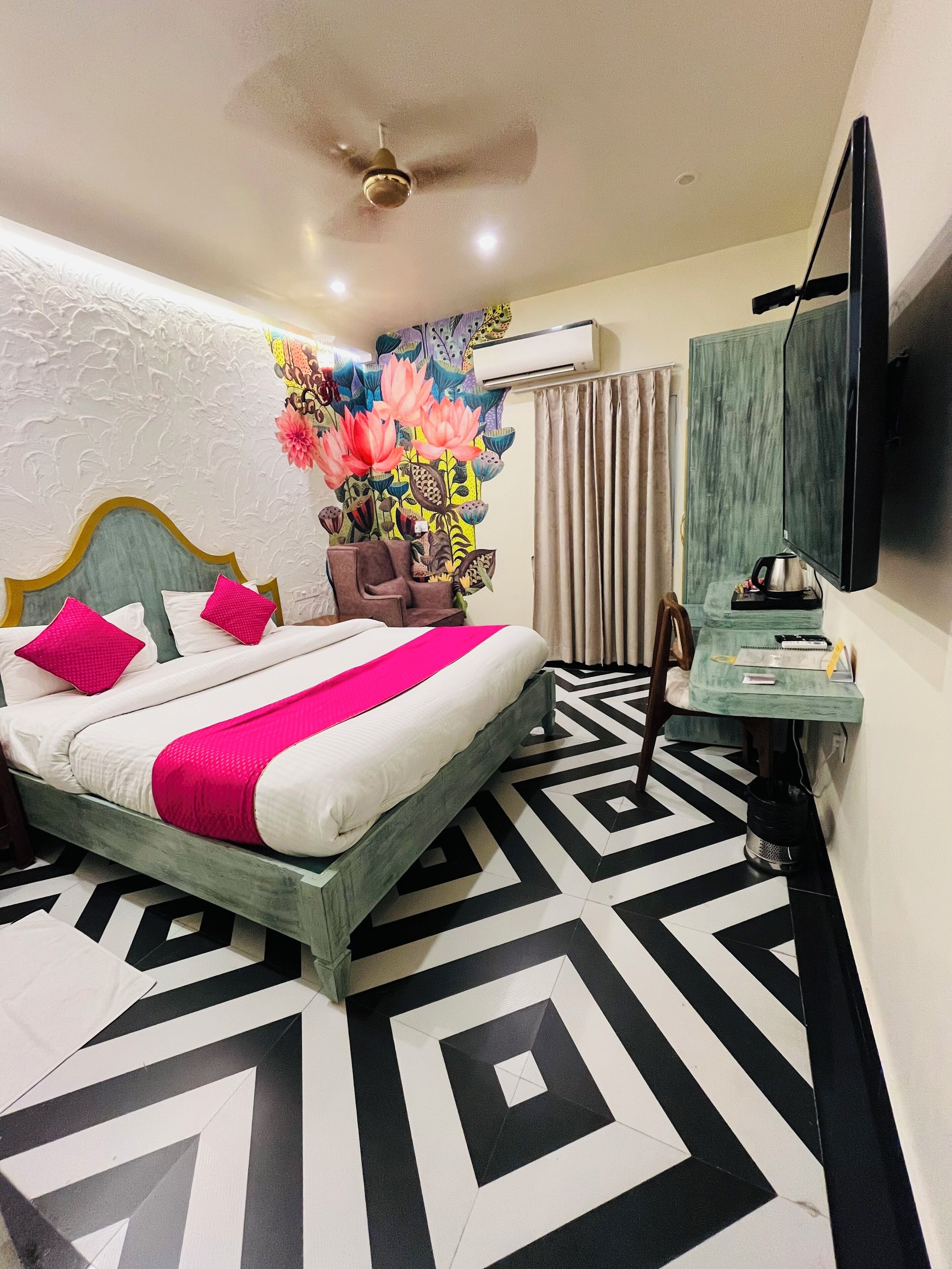 Une chambre d’hôtel équipée d’un lit, d’un bureau, d’une chaise, d’une télévision et d’un appareil de climatisation.