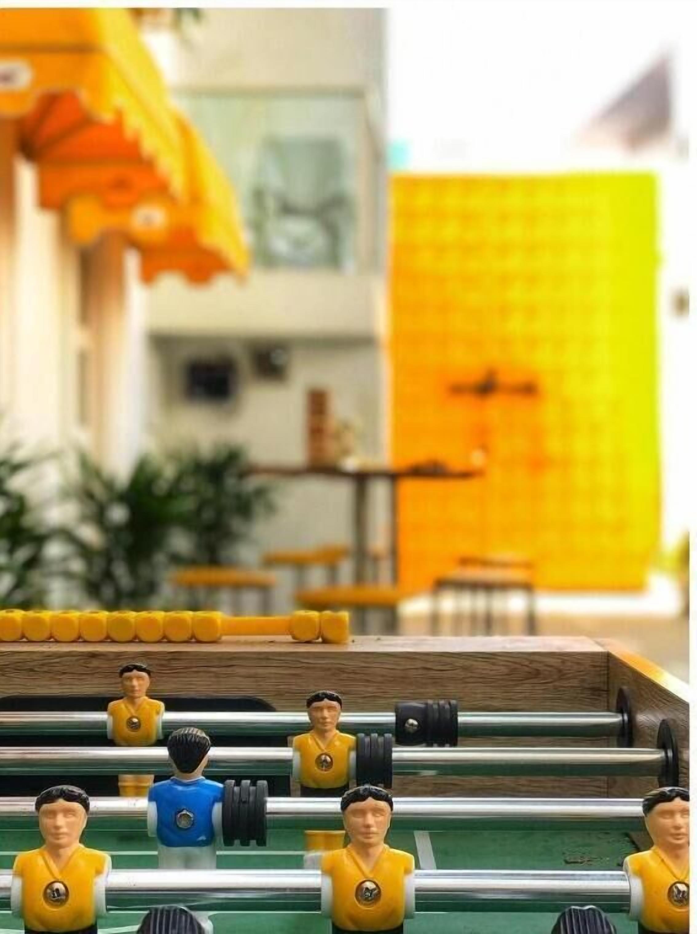 A foosball table with miniature figures in yellow and blue uniforms.