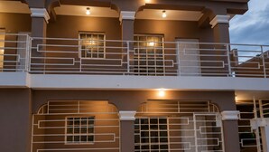A multi-story building with balconies, railings, and windows.