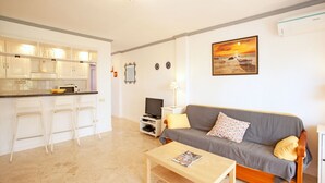 A compact living space with a kitchenette, a sofa, a coffee table, and a TV. - House in Marbella Near Sandy Beach (Marbella)