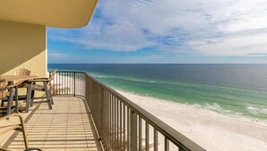A balcony with a view of the beach and ocean.