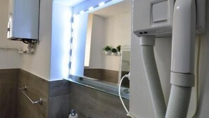 Un baño con un lavamanos blanco, un espejo y un teléfono blanco.