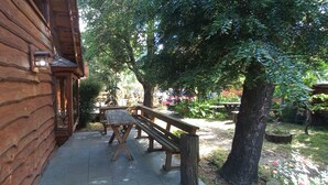 A wooden cabin with a stone bench and a wooden fence. - Cabañas Rucapillan (Panguipulli)