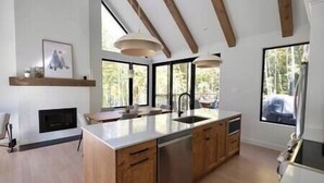 Une cuisine moderne avec des meubles en bois, un îlot central et de grandes fenêtres.