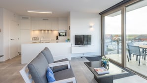 Eine moderne Wohnung mit Küche, Wohnbereich und Balkon.