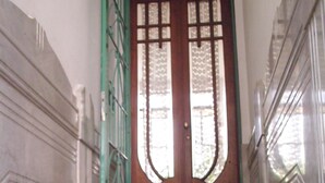 A marble staircase leading to a wooden door with glass panels. - Little Sunny Loft (Buenos Aires)