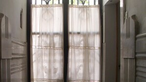 A hallway with a double door, a patterned rug, and a window with decorative ironwork. - Little Sunny Loft (Buenos Aires)