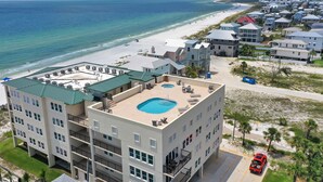 A multi-story hotel with a rooftop pool, beach view, and a parking area. - Beachfront Condo • Rooftop Pool • Sleeps 8 (Mexico Beach)