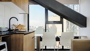 Una cocina moderna con encimera de madera, un grifo negro y ventana con vistas a un paisaje urbano.