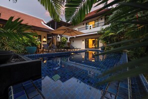 A swimming pool with blue tiles, surrounded by lounge chairs and potted plants. - Villa Meraya by Tropiclook   (Rawai)