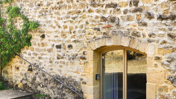 A stone building with a wooden door and steps leading up to it. - Le Point du Jour, a charming house (SAPOGNE SUR MARCHE)