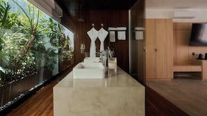 A modern bathroom with a large sink, towel rack, and a TV. - Casa Carmen Xólotl (Oaxaca)