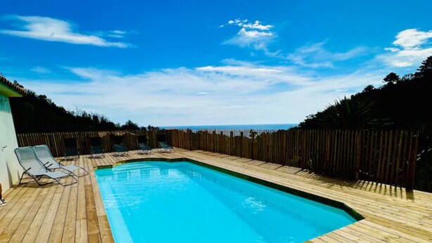 A rectangular swimming pool with a wooden deck, surrounded by a wooden fence. - Mare è Machja RDC • Sea view - Heated swimming pool - 6 people (Sari-Solenzara)
