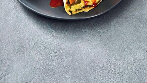 A plate with a burrito and orange slices.